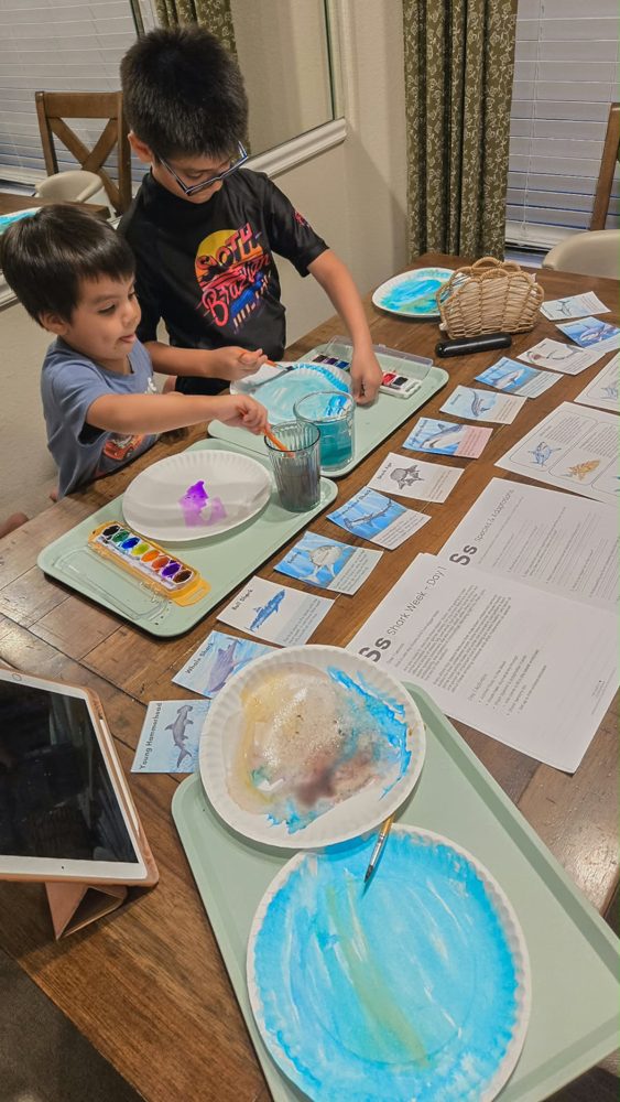 Brothers painting together at the table